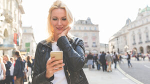 A woman is consenting to receive mass text messages while on her phone.