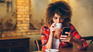 A student on a coffee break checking her text messages for updates on her class.