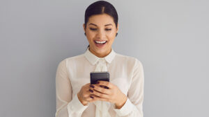 A woman sending a quick text as a reminder for a corporate event.